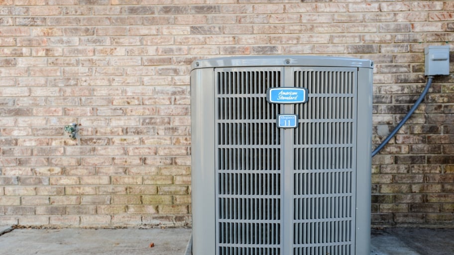 An air conditioning unit sits outside a structure.